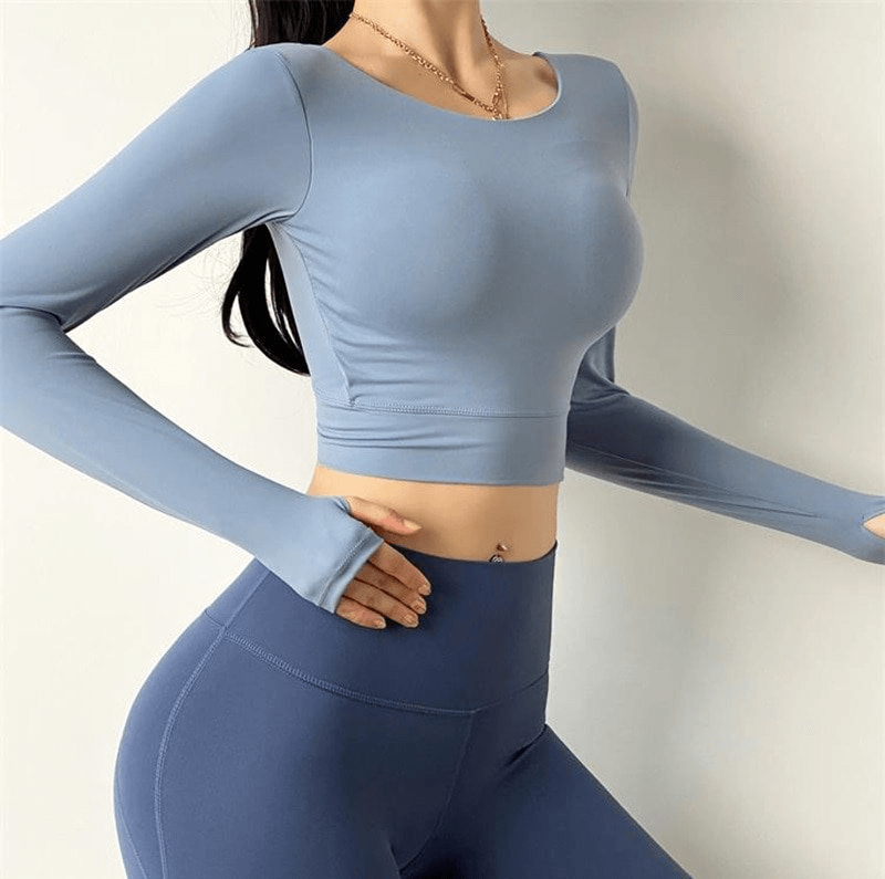 Sporty elastic cropped women's top with open back and long sleeves, perfect for workouts, featuring quick dry and moisture wicking technology.